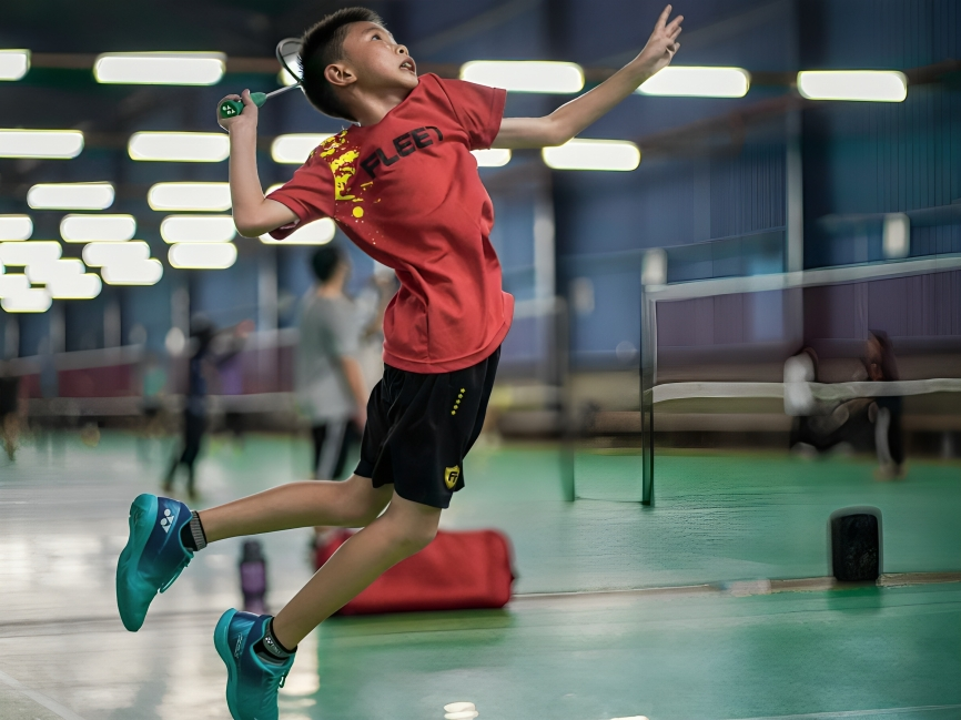 Atlet muda pebulu tangkis melakukan jumping smash di lapangan indoor dalam rangkaian tur BWF. sumber: pexels.com